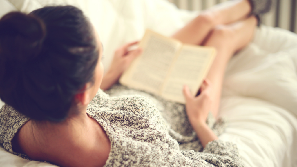 ベッドの上で読書する女性